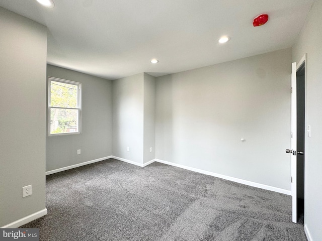 unfurnished room with recessed lighting, baseboards, and dark carpet