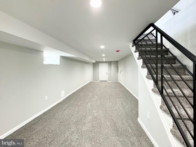 finished below grade area featuring recessed lighting, baseboards, carpet floors, and stairway