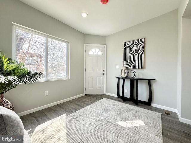 foyer entrance featuring dark wood-style floors and baseboards