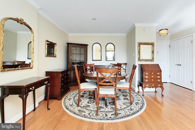 dining space with baseboards, wood-type flooring, and crown molding