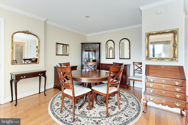 dining space featuring baseboards, crown molding, and light wood-style floors