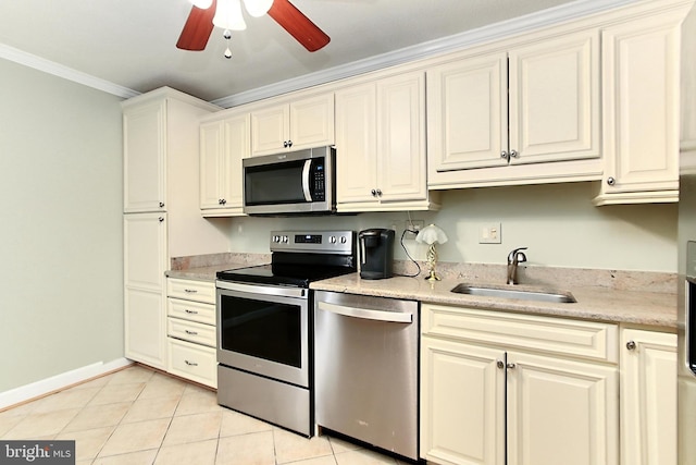 kitchen with ornamental molding, a ceiling fan, a sink, appliances with stainless steel finishes, and light tile patterned flooring