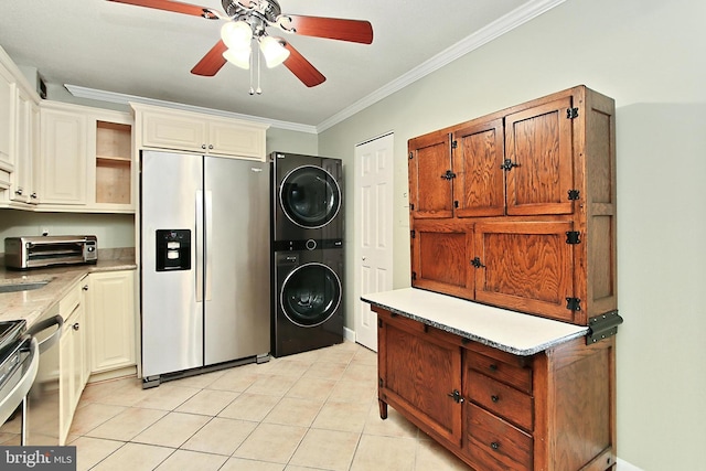 clothes washing area with crown molding, ceiling fan, a toaster, stacked washer and dryer, and light tile patterned floors