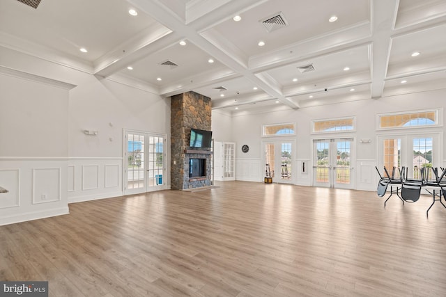 unfurnished living room with beam ceiling, visible vents, and french doors