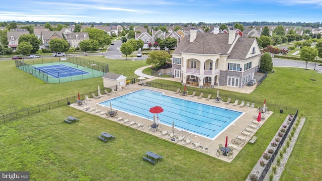 community pool featuring a patio area, a yard, and fence