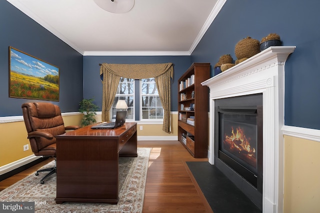 home office featuring dark wood finished floors, a fireplace with flush hearth, baseboards, and ornamental molding