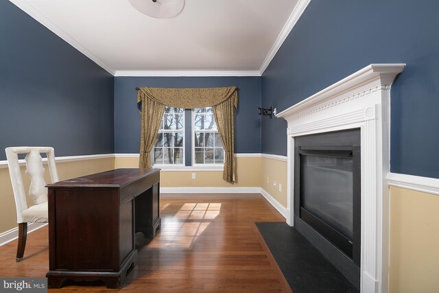 office area with a fireplace with flush hearth, baseboards, crown molding, and dark wood-type flooring