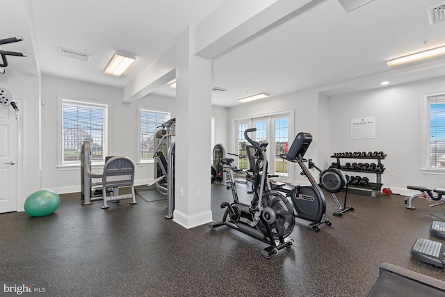 exercise room featuring visible vents, baseboards, and a wealth of natural light