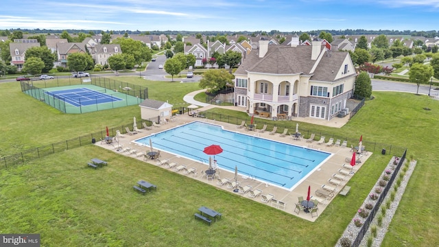 pool featuring a patio area, a yard, fence, and a residential view