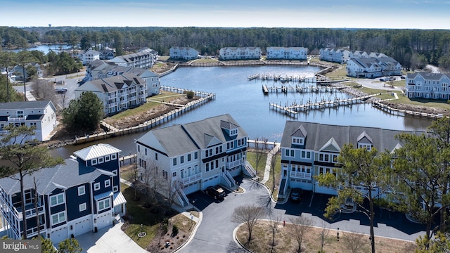 birds eye view of property featuring a wooded view and a water view