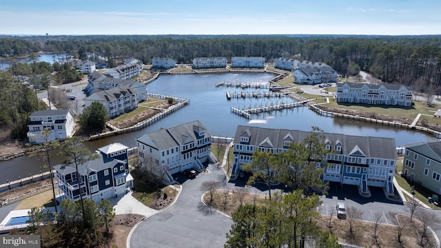 drone / aerial view featuring a residential view, a view of trees, and a water view