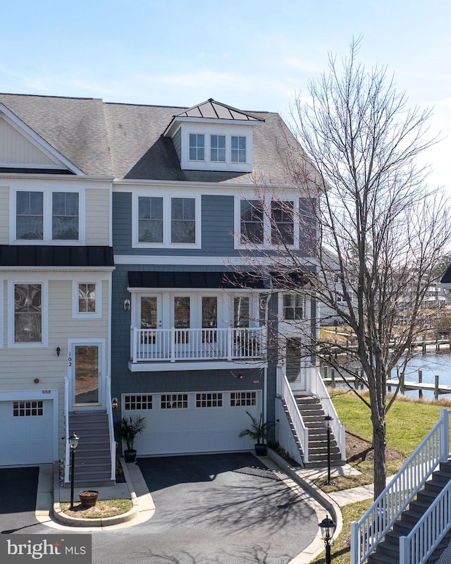 view of front of property with aphalt driveway, stairway, and an attached garage