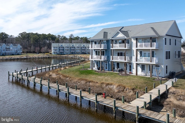 dock area with central air condition unit, a yard, and a water view