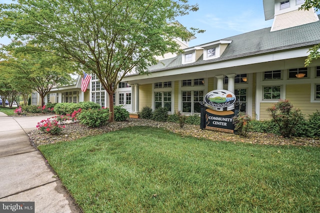 exterior space featuring driveway, a shingled roof, and a front yard