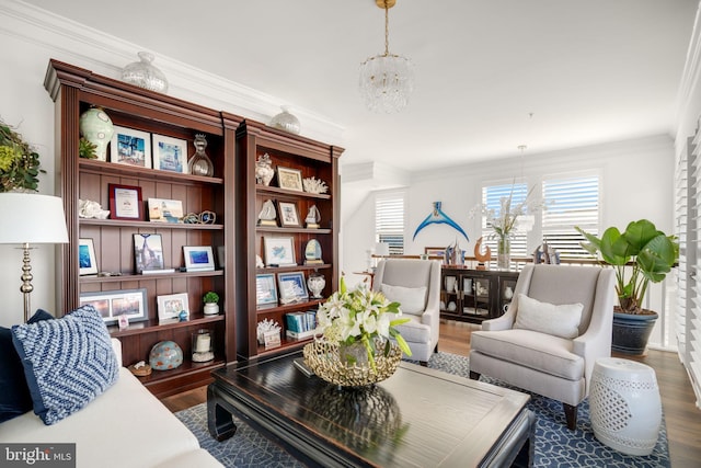 sitting room with crown molding, wood finished floors, and a chandelier