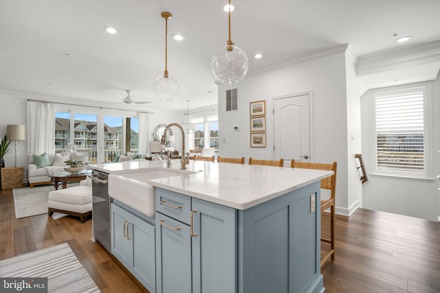 kitchen featuring a sink, dark wood-type flooring, a kitchen bar, crown molding, and open floor plan