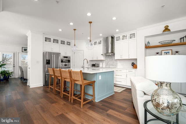 kitchen with appliances with stainless steel finishes, wall chimney exhaust hood, crown molding, and light countertops