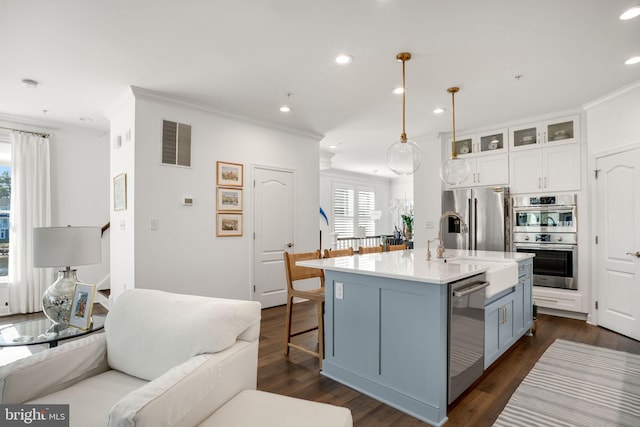 kitchen with visible vents, open floor plan, dark wood finished floors, appliances with stainless steel finishes, and a breakfast bar area