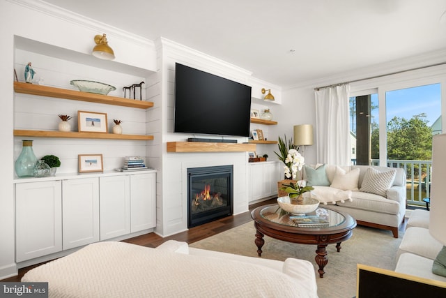 living area featuring a large fireplace, wood finished floors, and crown molding