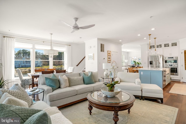 living room with visible vents, wood finished floors, recessed lighting, crown molding, and ceiling fan