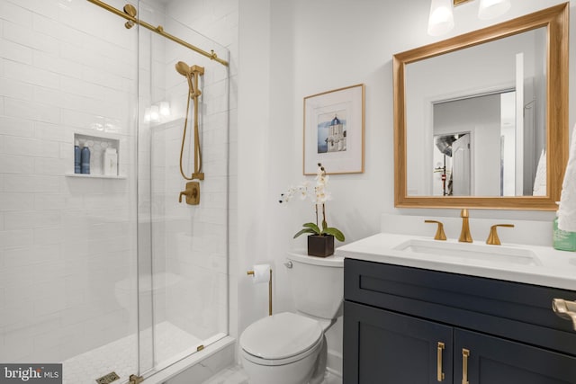 bathroom with vanity, a shower stall, and toilet