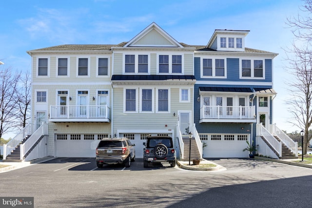 townhome / multi-family property with stairway, metal roof, an attached garage, and a standing seam roof