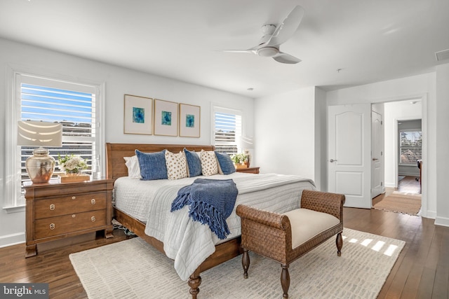 bedroom with dark wood finished floors, visible vents, baseboards, and a ceiling fan