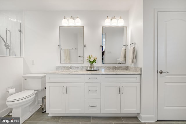 bathroom featuring double vanity, toilet, a shower, and a sink