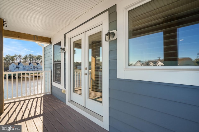 wooden terrace with french doors and a water view