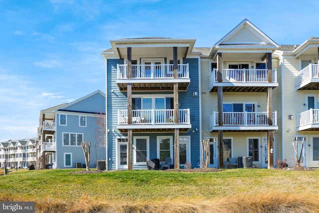 rear view of property featuring a yard and central air condition unit