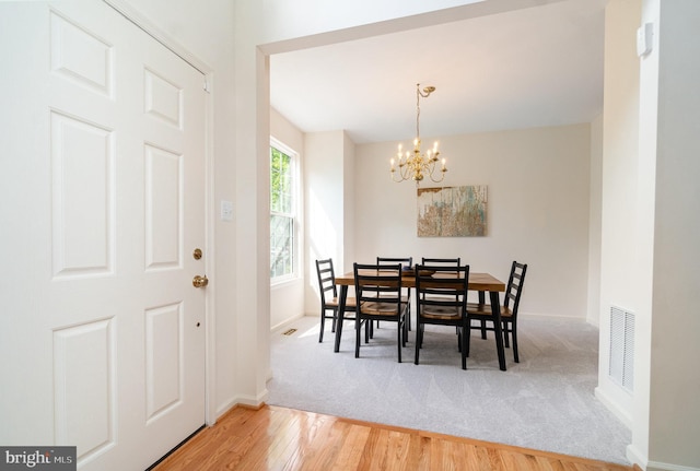 dining room with baseboards, visible vents, an inviting chandelier, wood finished floors, and carpet floors