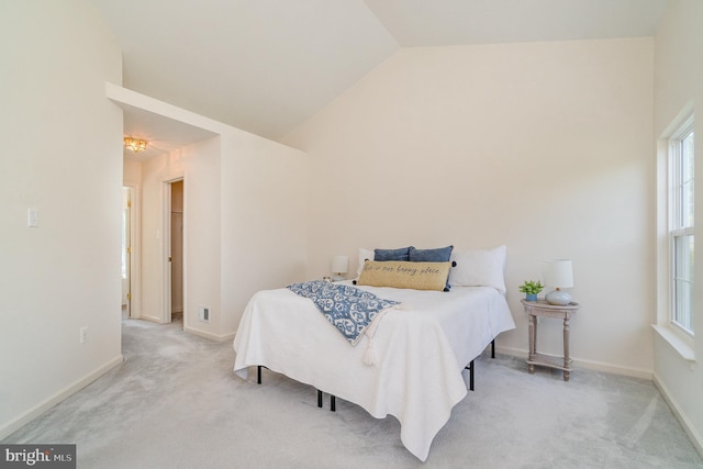 bedroom featuring lofted ceiling, baseboards, and light carpet