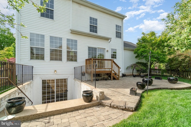 back of property with a lawn, fence, and a patio