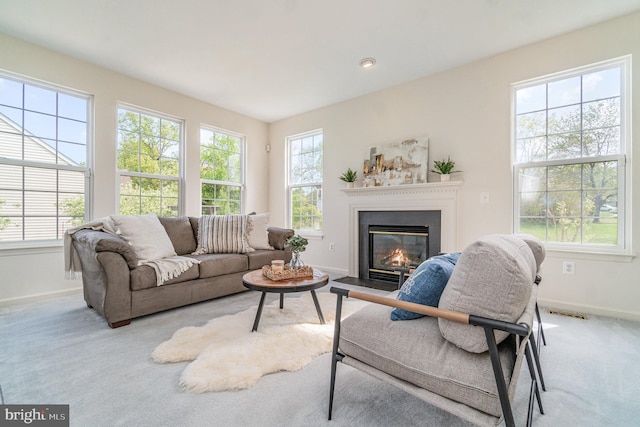carpeted living room featuring visible vents, a glass covered fireplace, and baseboards
