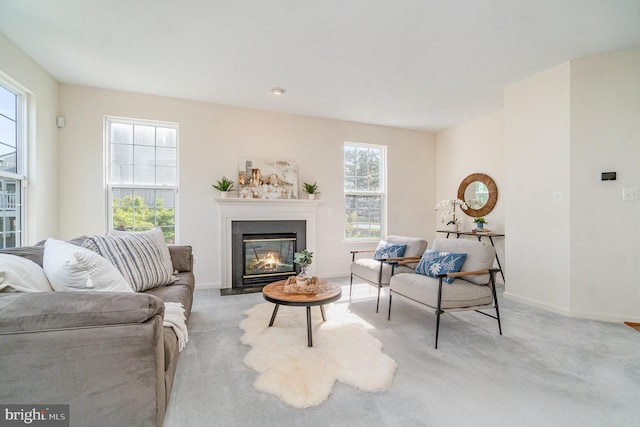 carpeted living room with a fireplace with flush hearth and baseboards