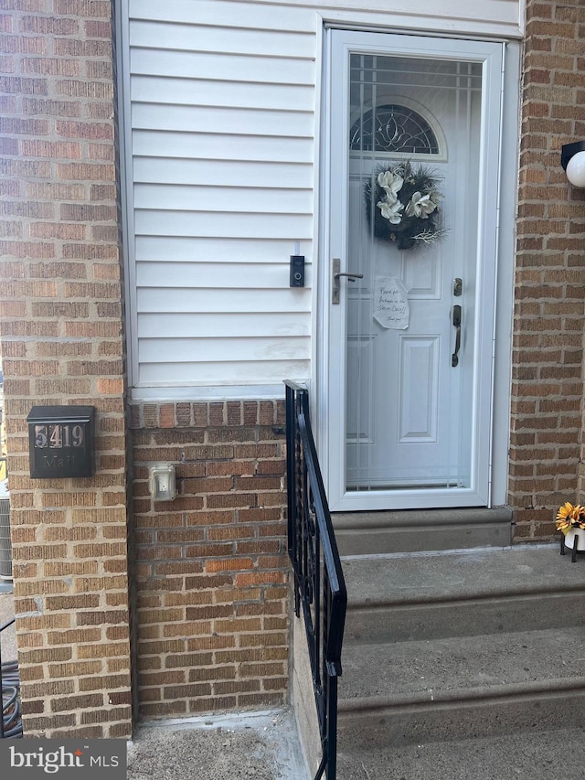 view of exterior entry featuring brick siding