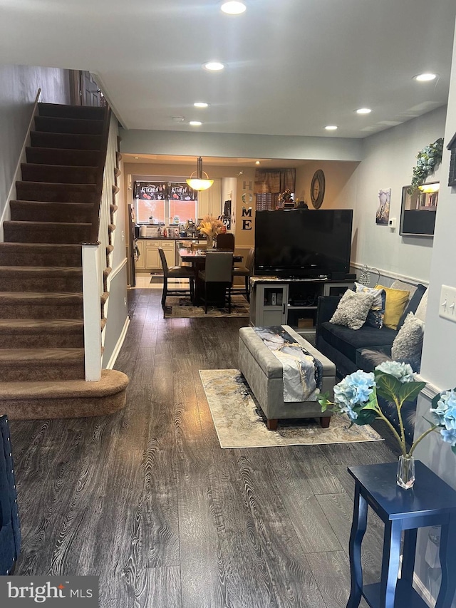 living area with stairs, recessed lighting, and wood finished floors