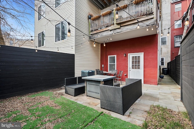 exterior space with central AC unit, a balcony, and a fenced backyard