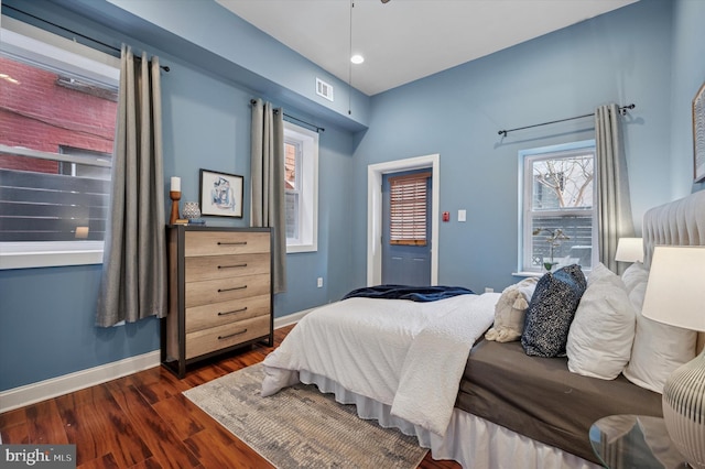 bedroom featuring baseboards, visible vents, and dark wood-style flooring