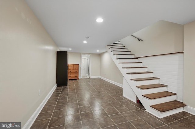 finished basement with dark tile patterned flooring, stairway, recessed lighting, and baseboards