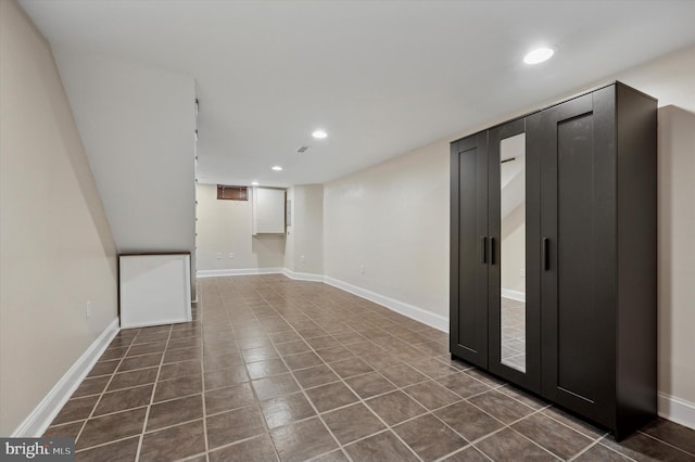 finished basement featuring recessed lighting, baseboards, and dark tile patterned floors