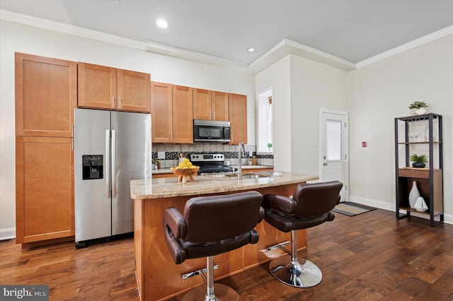 kitchen featuring dark wood-type flooring, ornamental molding, a sink, stainless steel appliances, and light stone countertops