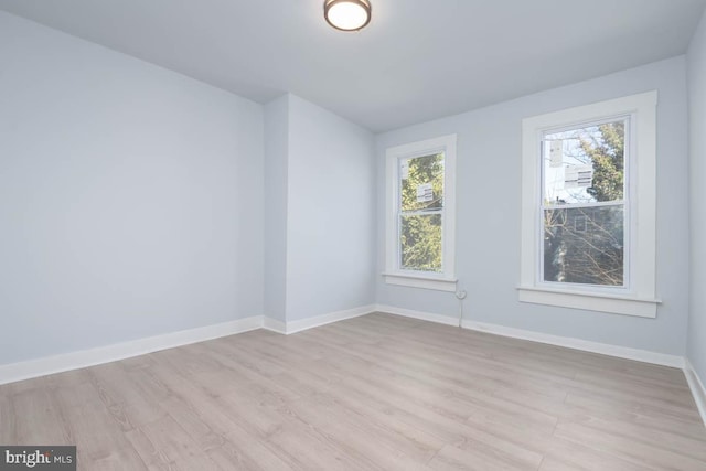 unfurnished room with light wood-style flooring and baseboards