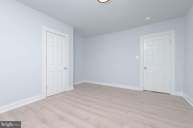 unfurnished room with light wood finished floors and baseboards