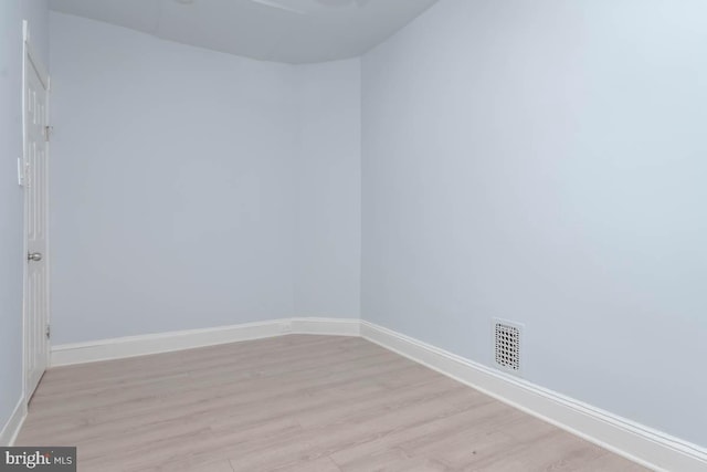 empty room featuring visible vents, baseboards, and light wood-style flooring