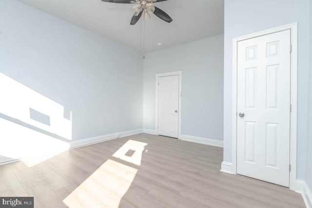 spare room with baseboards, wood finished floors, and ceiling fan