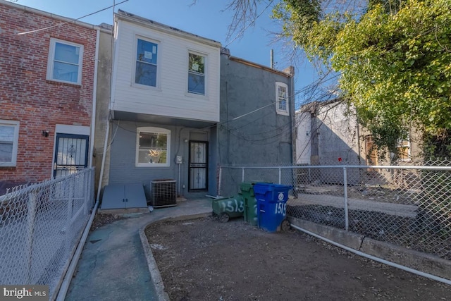 back of property featuring central AC unit and a fenced backyard