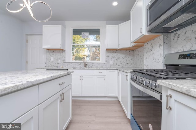 kitchen featuring white cabinetry, light stone counters, and stainless steel appliances