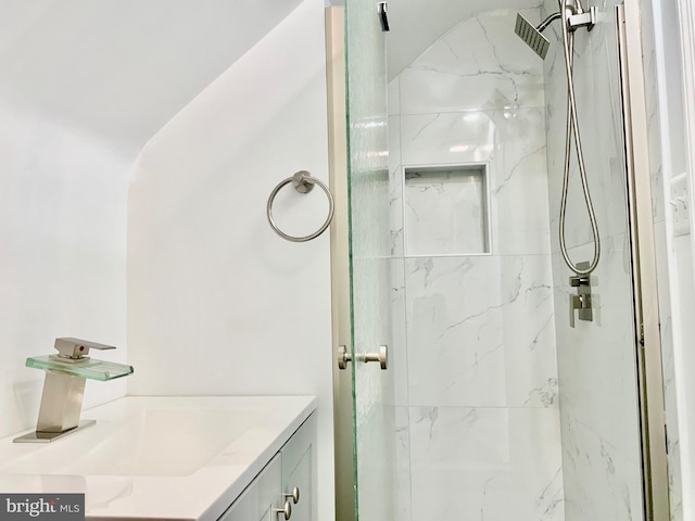 bathroom with a marble finish shower and vanity