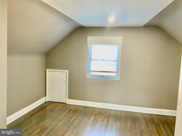 bonus room featuring vaulted ceiling, baseboards, and wood finished floors